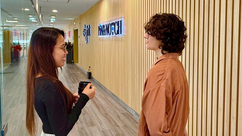 Two colleagues talking in the Pin&Notch office corridor