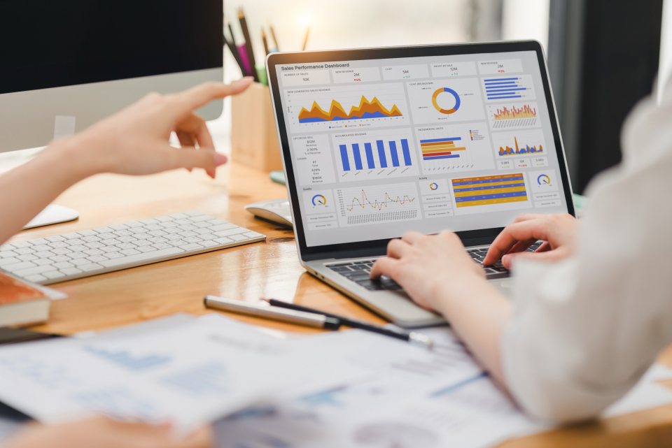 Charts and data on a laptop and printed reports